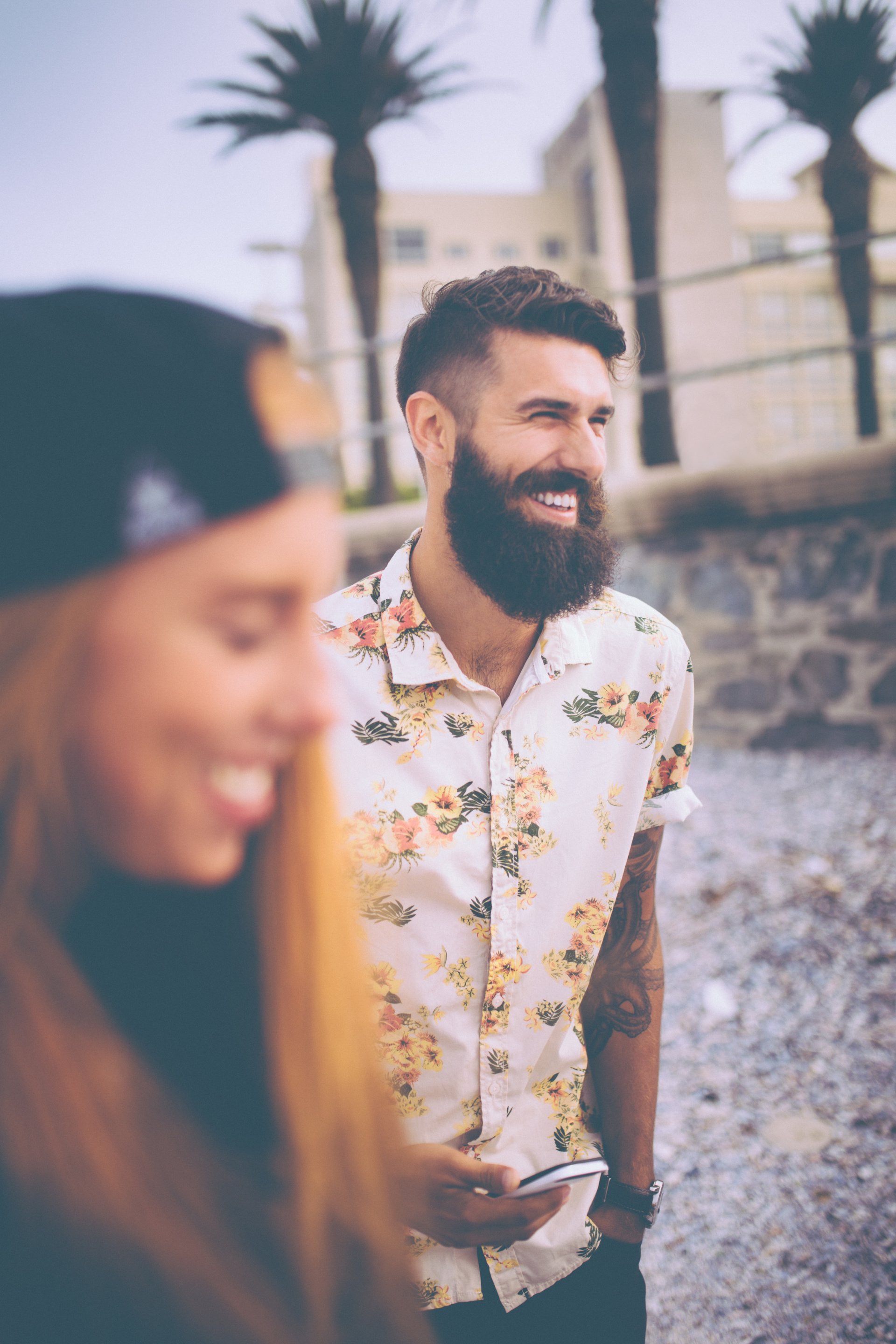 Smiling hipster guy with his girlfriend at the beach